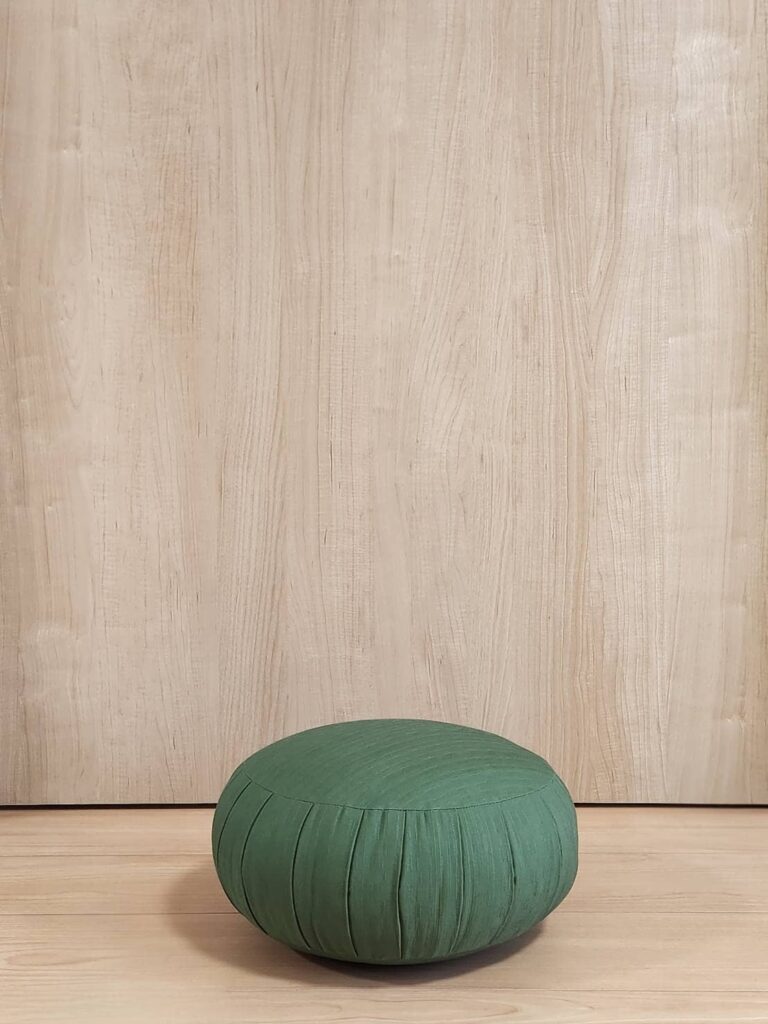 家の中で坐蒲の上で坐禅を組むイメージ